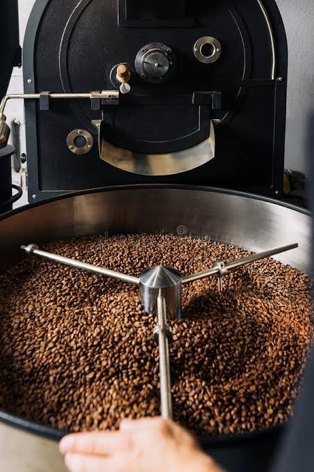 Roasted coffee turning in the cooling tray of a drum roaster.